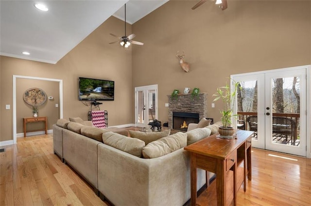 living area featuring french doors, light wood finished floors, and high vaulted ceiling