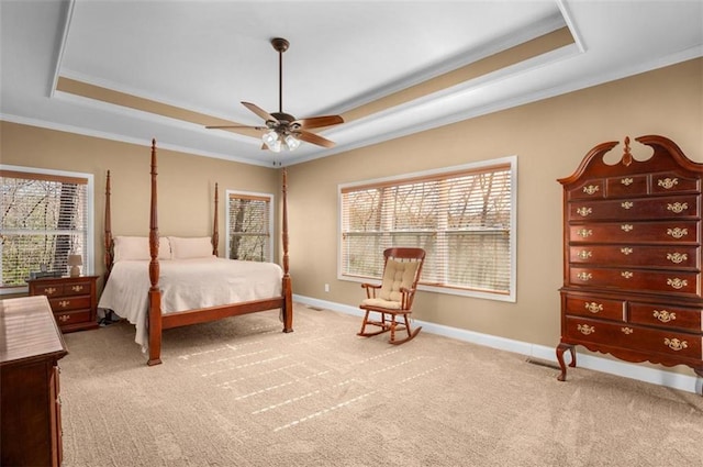 carpeted bedroom with baseboards, a raised ceiling, and crown molding