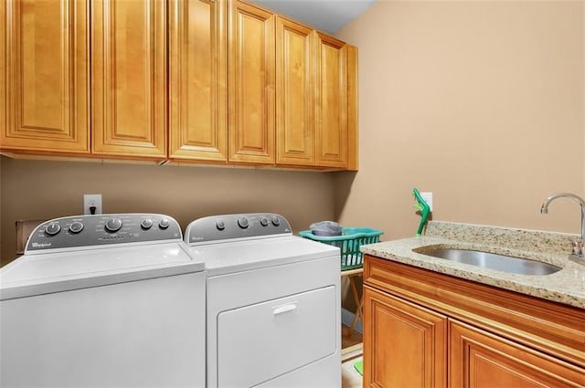 laundry room featuring cabinet space, washing machine and dryer, and a sink