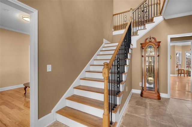 stairway featuring wood finished floors, baseboards, and ornamental molding