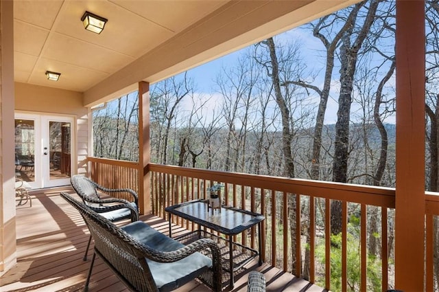 deck featuring french doors and a forest view