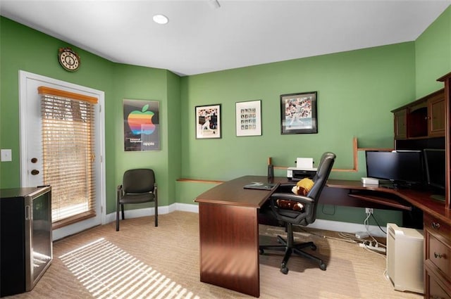 office area featuring baseboards and light colored carpet