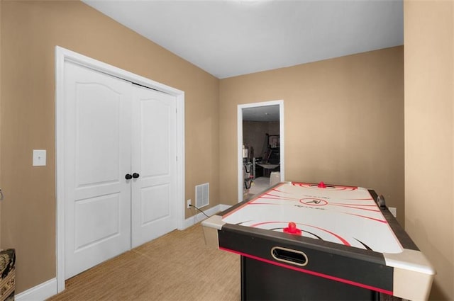 recreation room with carpet, visible vents, and baseboards