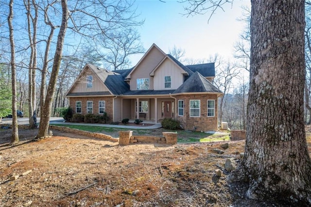 craftsman-style house featuring board and batten siding, a porch, and brick siding