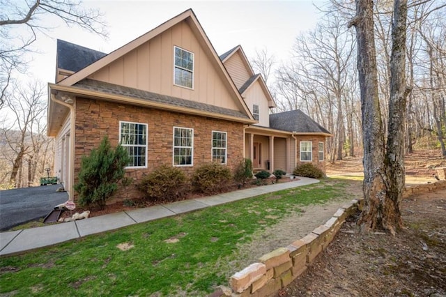 view of front of home featuring stone siding, board and batten siding, and roof with shingles