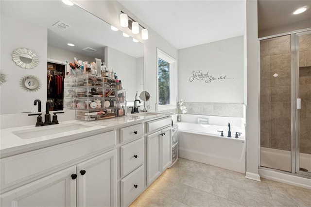 bathroom with tile patterned floors, vanity, and shower with separate bathtub