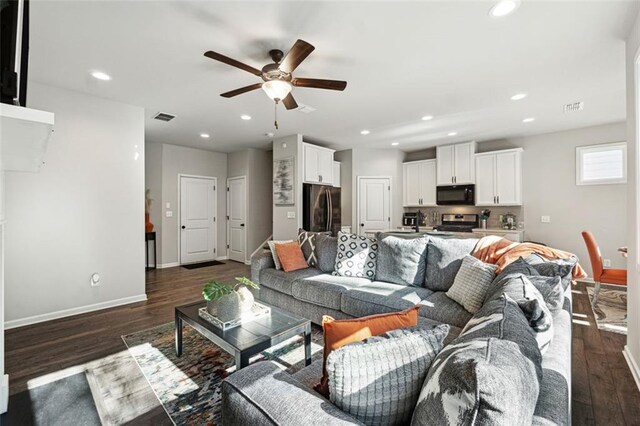 living room with ceiling fan and dark hardwood / wood-style floors