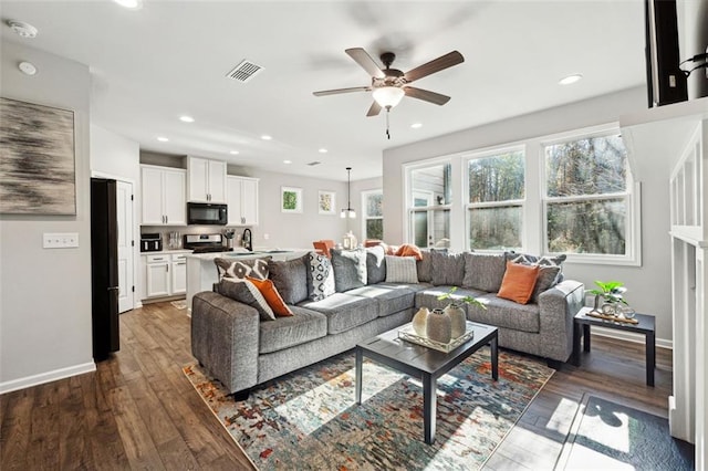 living room with ceiling fan, sink, and dark wood-type flooring