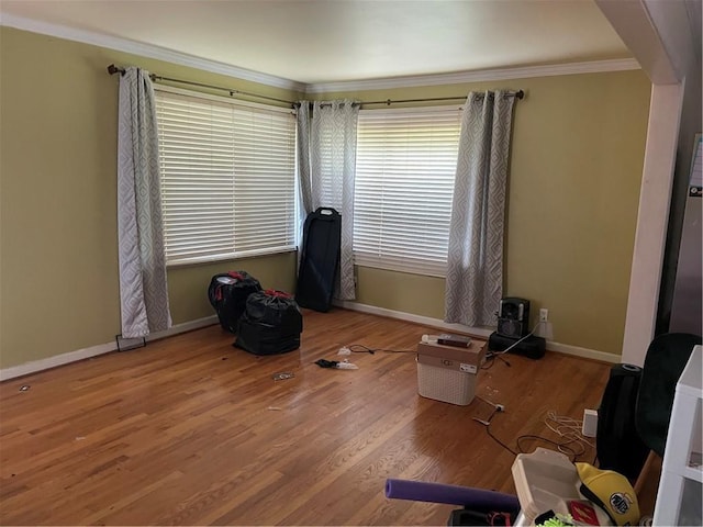 spare room featuring crown molding, wood finished floors, and baseboards