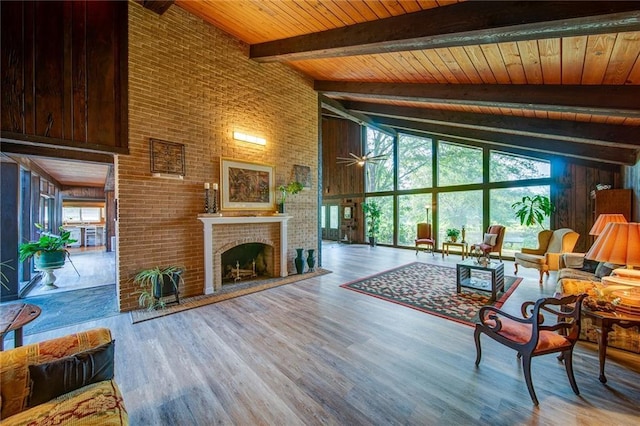 living room featuring high vaulted ceiling, a brick fireplace, beamed ceiling, a wall of windows, and light hardwood / wood-style floors