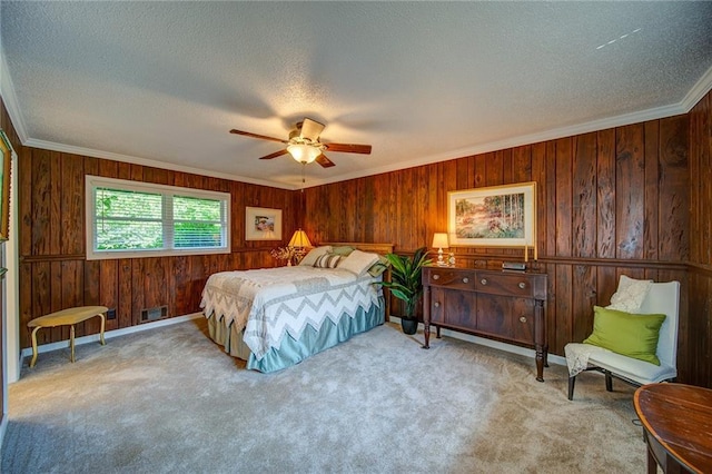 bedroom with crown molding, light colored carpet, ceiling fan, and a textured ceiling