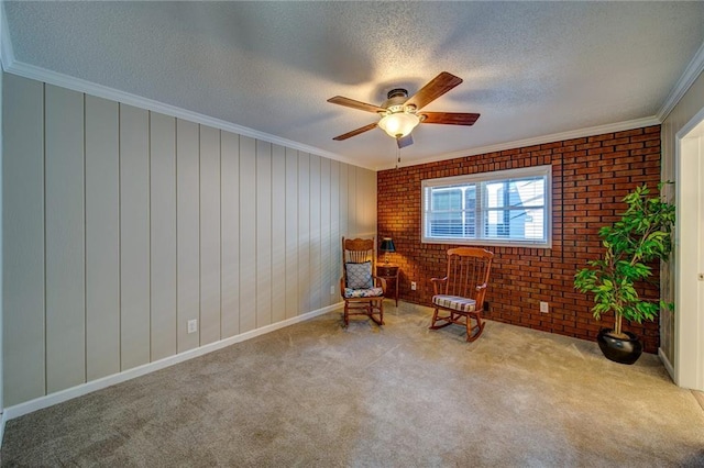 unfurnished room with crown molding, ceiling fan, carpet flooring, a textured ceiling, and brick wall