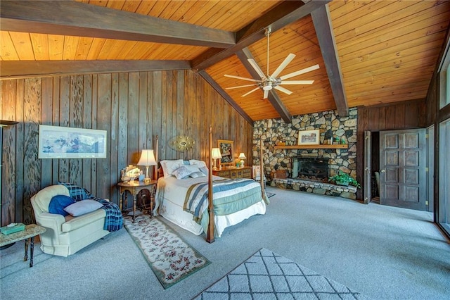 unfurnished bedroom with beam ceiling, a stone fireplace, carpet, and wooden ceiling