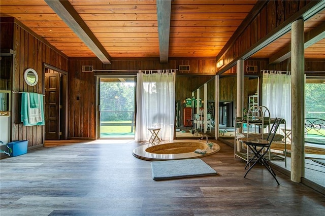 unfurnished room featuring hardwood / wood-style floors, wood ceiling, beamed ceiling, and wood walls