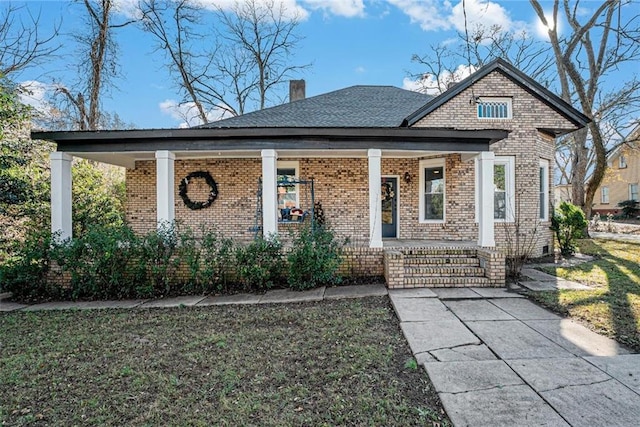 view of front of home with covered porch and a front lawn