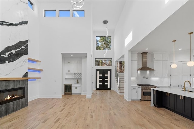 unfurnished living room with a healthy amount of sunlight, sink, and light hardwood / wood-style floors