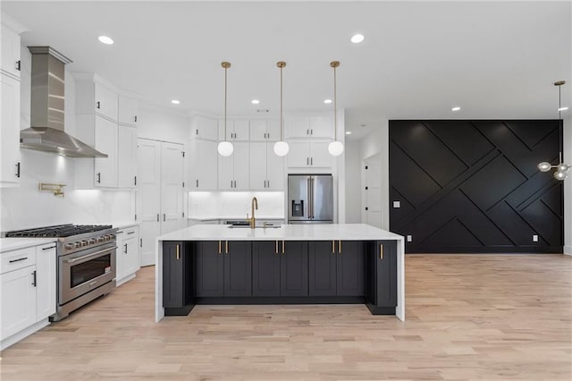 kitchen with pendant lighting, wall chimney range hood, a spacious island, and appliances with stainless steel finishes