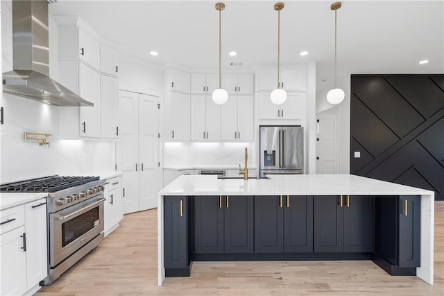 kitchen featuring wall chimney range hood, a large island, sink, and premium appliances