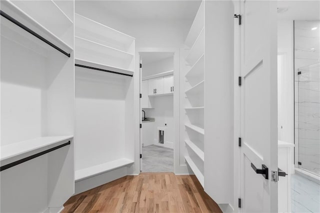 walk in closet featuring sink and light hardwood / wood-style flooring