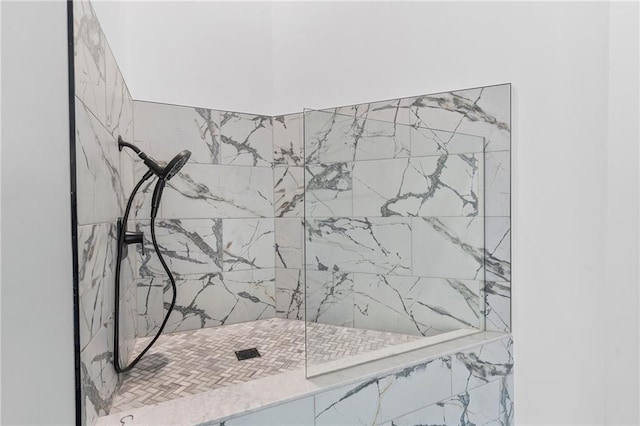 interior details featuring a tile shower