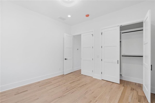 unfurnished bedroom with a closet and light wood-type flooring