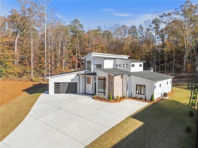 contemporary house with a garage, central AC unit, and a front lawn