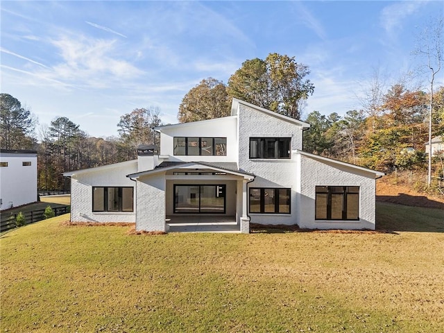 rear view of property featuring a yard and a patio area