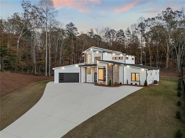 contemporary home with a garage and a lawn