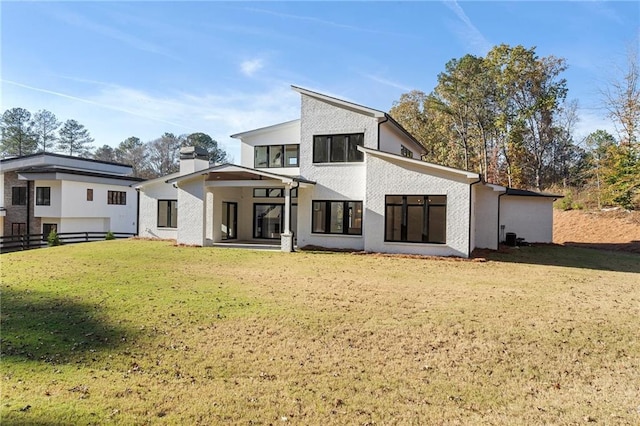 rear view of house featuring a yard