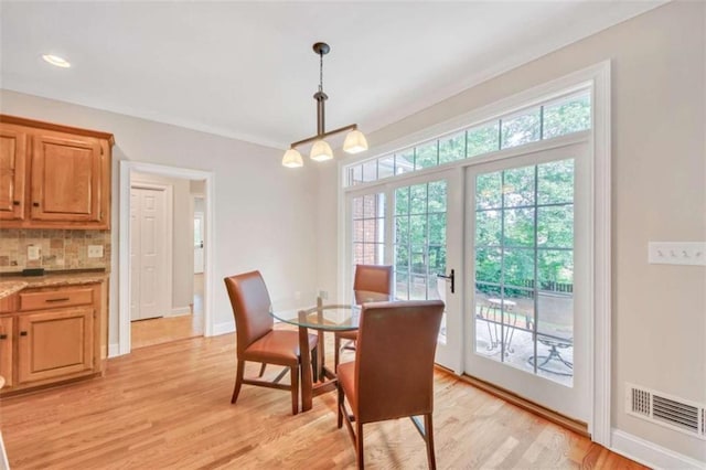 dining area with light wood-style floors, baseboards, and a chandelier