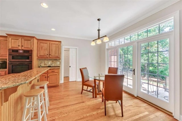 dining room with crown molding, a chandelier, light wood-type flooring, and recessed lighting