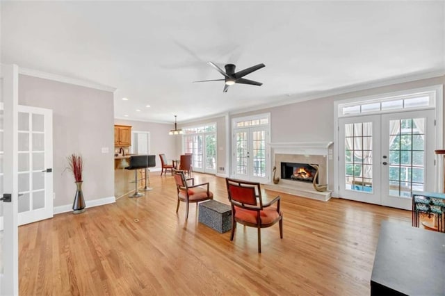 living room with french doors, ornamental molding, light wood finished floors, ceiling fan, and recessed lighting