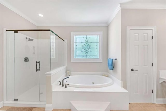 bathroom with a bath, a stall shower, crown molding, and baseboards