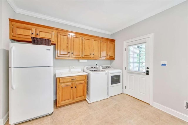 washroom with washing machine and clothes dryer, ornamental molding, baseboards, and cabinet space