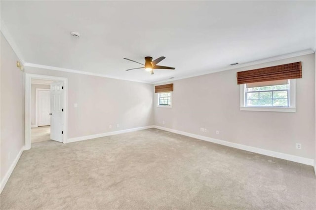 spare room featuring crown molding, light carpet, ceiling fan, and baseboards