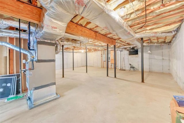 unfinished basement featuring heating unit
