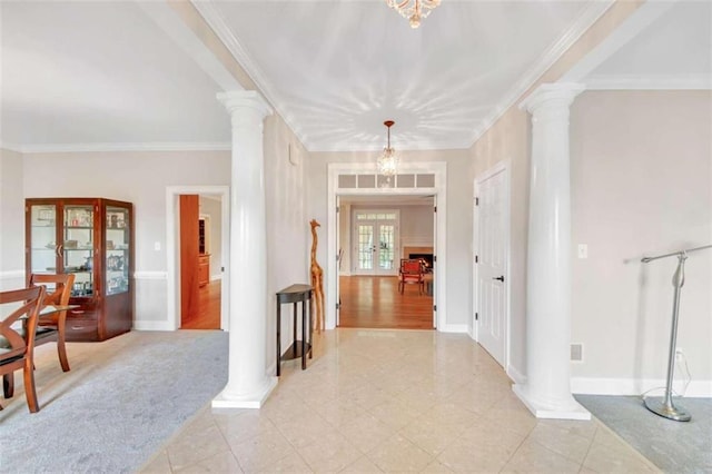 entrance foyer featuring ornate columns, ornamental molding, and baseboards