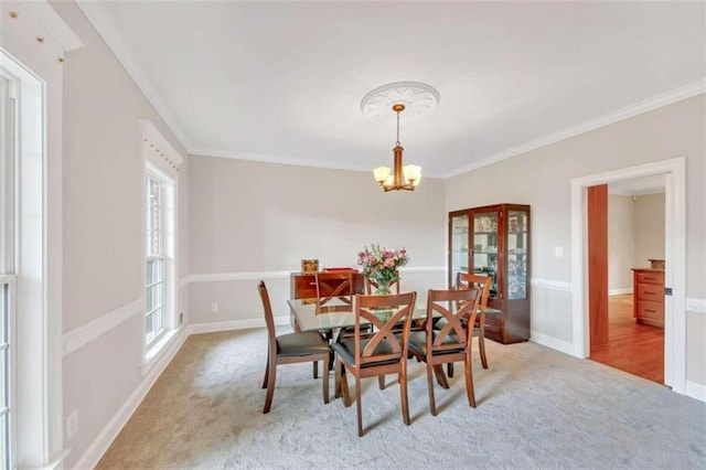dining room featuring carpet, ornamental molding, a chandelier, and baseboards