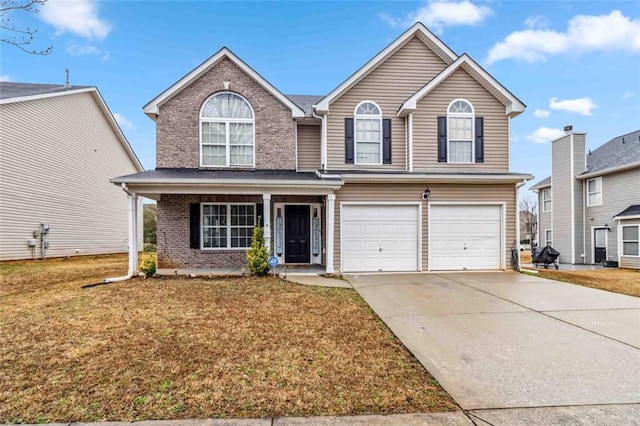 front of property featuring a garage, a front yard, and covered porch