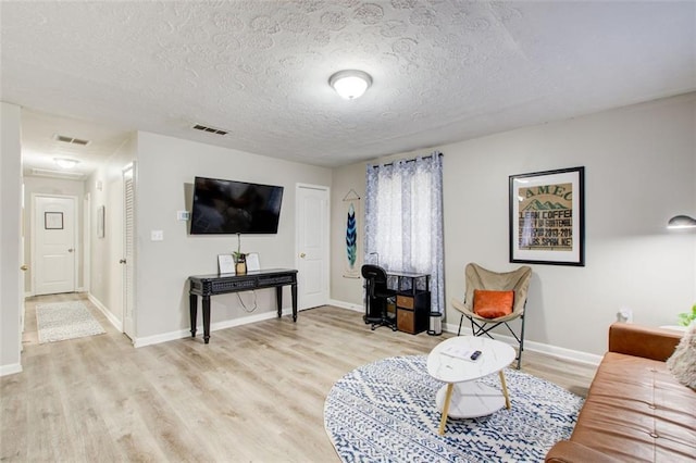 1351 Eason St NW, Atlanta, GA 30314 - living room featuring baseboards, light wood-style flooring, visible vents, and a textured ceiling