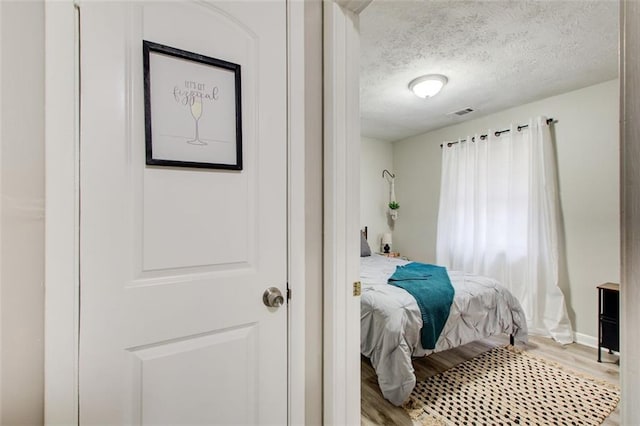 1351 Eason St NW, Atlanta, GA 30314 - bedroom featuring visible vents, a textured ceiling, baseboards, and wood finished floors