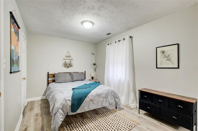 1351 Eason St NW, Atlanta, GA 30314 - bedroom with a textured ceiling, light wood finished floors, visible vents, and baseboards