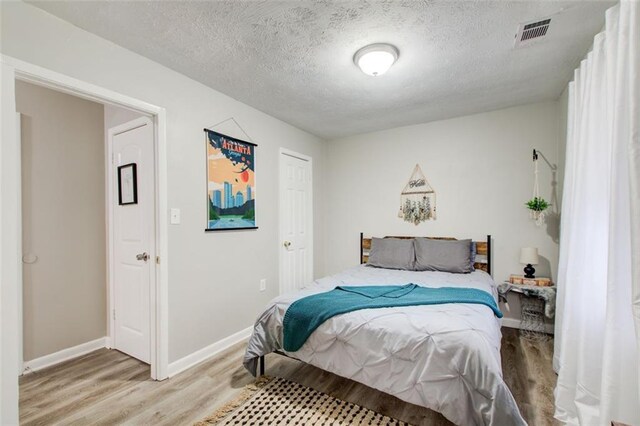 1351 Eason St NW, Atlanta, GA 30314 - bedroom featuring visible vents, a textured ceiling, baseboards, and wood finished floors