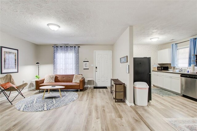 1351 Eason St NW, Atlanta, GA 30314 - living room with light wood-style floors, baseboards, and a textured ceiling