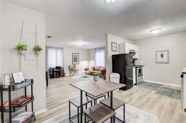 1351 Eason St NW, Atlanta, GA 30314 - dining room with visible vents, baseboards, a textured ceiling, and light wood finished floors