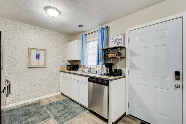 1351 Eason St NW, Atlanta, GA 30314 - kitchen featuring a sink, wallpapered walls, white cabinetry, and stainless steel dishwasher