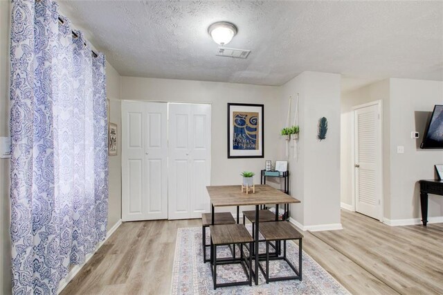 1351 Eason St NW, Atlanta, GA 30314 - dining space with light wood finished floors, visible vents, baseboards, and a textured ceiling