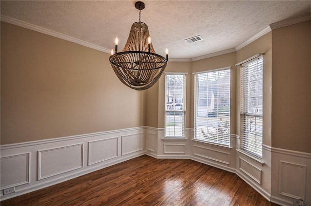 unfurnished dining area featuring dark wood-type flooring, an inviting chandelier, a textured ceiling, and a wealth of natural light