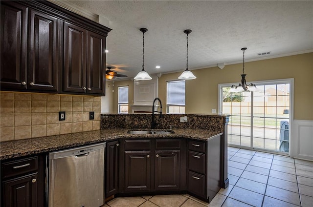 kitchen with sink, dark brown cabinets, dark stone countertops, dishwasher, and pendant lighting