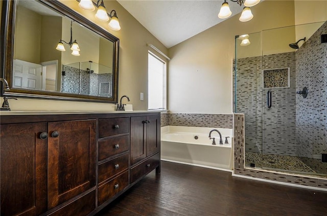 bathroom with lofted ceiling, hardwood / wood-style flooring, vanity, plus walk in shower, and a chandelier